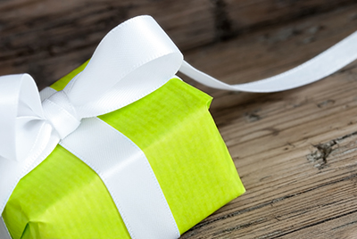 Green Present with White Ribbon, Closeup on Wood